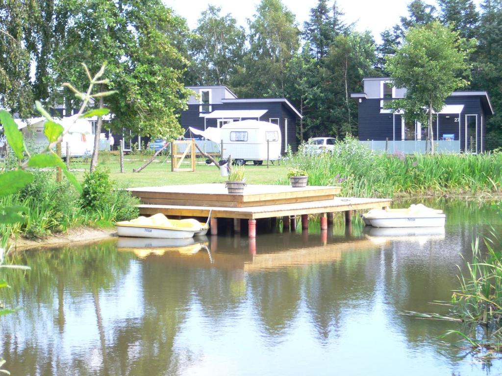 Grønne campingarealer og campingvogne ved pladsens sø